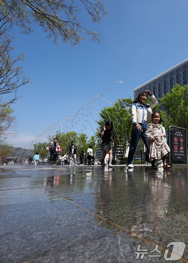 봄철 마지막 절기 곡우(穀雨)인 20일 서울 광화문광장에서 시민과 관광객들이 분수터널을 지나고 있다. 2025.4.20/뉴스1 ⓒ News1 허경 기자