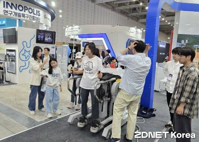 관람객이 팔과 다리 움직임으로 장비를 조작하는 모습.