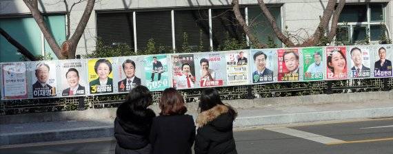 제20대 대통령선거(2022년 3월9일)을 앞두고 지난 2022년 2월 18일 부산 연제구에서 시민들이 건물 담장에 첩부된 대선 후보자의 선거벽보 살펴보있다. 뉴시스