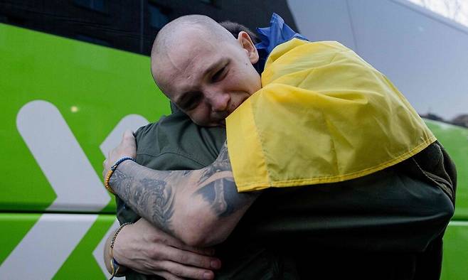 지난 19일(현지시각) 미확인 장소에서 포로 교환으로 석방된 우크라이나 포로가 사랑하는 사람을 안고 기쁨의 눈물을 흘리고 있다. AFP 연합뉴스