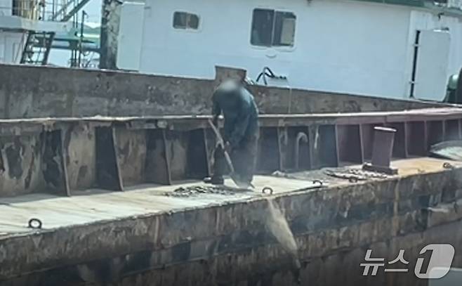 21일 전남 목포시 남항부두에서 한 선박 관계자가 수리 작업 중 바다에 폐기물을 무단 투기하고 있는 모습.(목포해경 제공. 재판매 및 DB 금지)