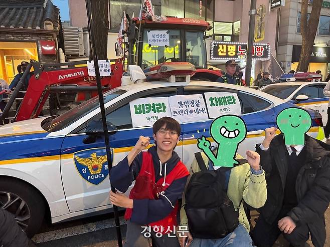 청소년인권행동 아수나로 상근활동가 수영(활동명·18)이 지난달 26일 서울 종로구 집회 현장의 전국농민회총연맹의 트랙터와 경찰차 앞에서 사진을 찍고 있다. 수영 제공