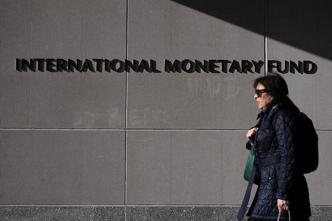 A woman walks past the International Monetary Fund building in Washington, DC. (AFP-Yonhap)