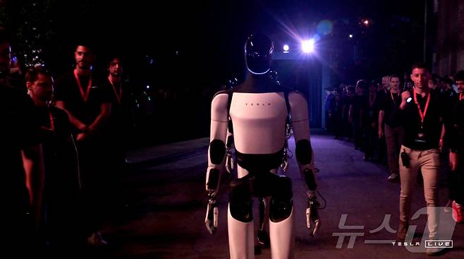 테슬라가 개발한 옵티머스 로봇이 캘리포니아주 로스앤젤레스에서 열린 테슬라 로보택시 공개 행사장을 누비고 있다. ⓒ 로이터=뉴스1
