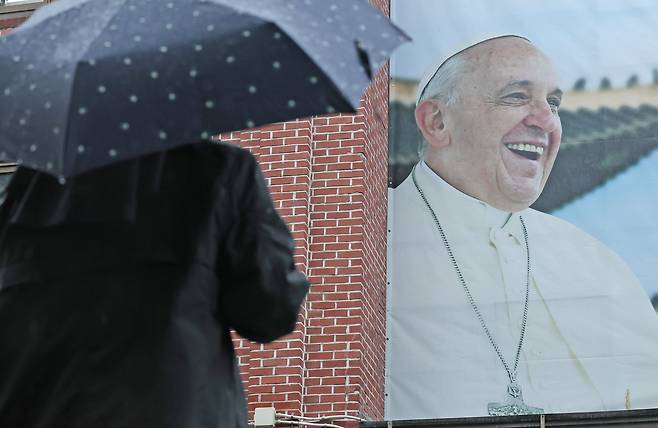 22일 오전 서울 중구 명동성당에서 수녀가 건물 외벽에 붙은 프란치스코 교황의 사진을 바라보고 있다. /뉴스1