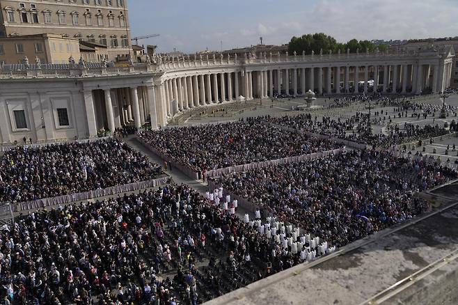 바티칸 성베드로 광장을 가득 메운 평신도들이 23일 프란치스코 교황의 유해가 안치된 관이 사제들의 행렬을 따라 성베도로 대성당으로 옮겨지는 모습을 지켜보고 있다. 2025.04.23. 바티칸시티=AP/뉴시스