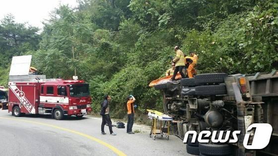 전북 완주군 구이면 염암마을 염재 내리막길 도로에서 벼를 실은 8톤 트럭(운전자 A씨·38)이 전도돼 있는 것을 인근을 지나가던 운전자가 발견해 119에 신고해 출동한 소방대원에 의해 구조작업이 벌어지고 있다.(전주완산소방서 제공)2016.9.7/뉴스1 ⓒ News1