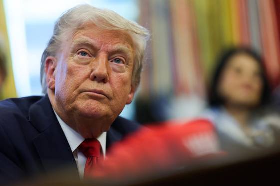 도널드 트럼프 미국 대통령이 23일(현지시간) 백악관 집무실에서 행정명령에 서명한 뒤 기자들과 대화하고 있다. 로이터=연합뉴스