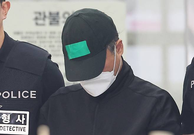 부모와 처자식 등 5명을 살해한 50대 가장 A씨가 24일 경기도 용인동부경찰서 유치장에서 검찰로 송치되고 있다. 연합뉴스