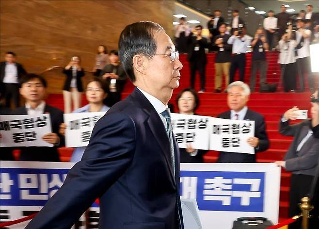 한덕수 대통령 권한대행 국무총리가 24일 국회에서 열린 추가경정예산안 시정연설을 위해 국회본청으로 들어서고 있다. 한 대행 뒤로 야4당(조국혁신당·진보당·기본소득당·사회민주당) 의원들이 한 대행을 규탄하는 피켓을 들고 있다. ⓒ데일리안 홍금표 기자