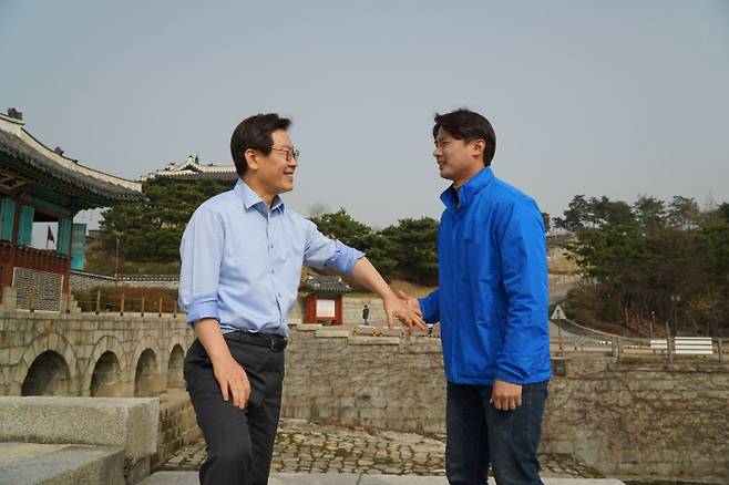 이재명 전 대표가 청소년 시절 공장일을 하다 다쳐 굽은 팔로 황대호 위원장 손을 잡고 있는 모습. 2018년 지방선거 예비후보 시절에 촬영한 사진이다. 황 위원장 측 제공