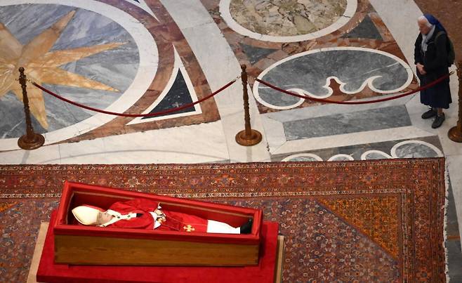 프랑스 출신의 제느비에브 자넹그로스 수녀가 23일(현지시간) 바티칸 성 베드로 대성전에 안치된 프란치스코 교황의 관 곁으로 다가가 조문하고 있다. 연합뉴스