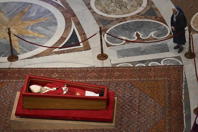 제네비에브 제닝로스 수녀가 23일(현지 시간) 관에 누워 있는 프란치스코 교황을 오랫동안 지켜보고 있다. 바티칸=AP뉴시스