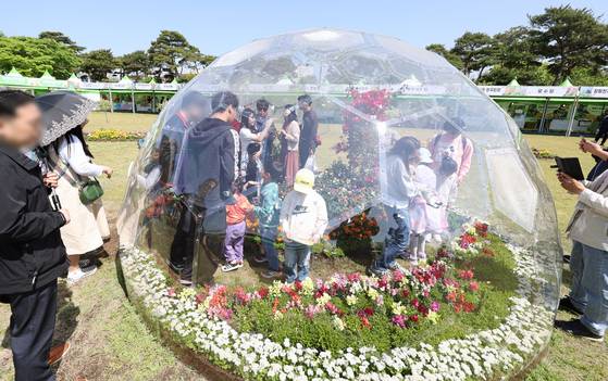 '2023 함평나비대축제'가 열렸던 전남 함평군 함평엑스포공원에서 방문객들이 봄꽃과 함께 사진을 찍고 있다. 연합뉴스
