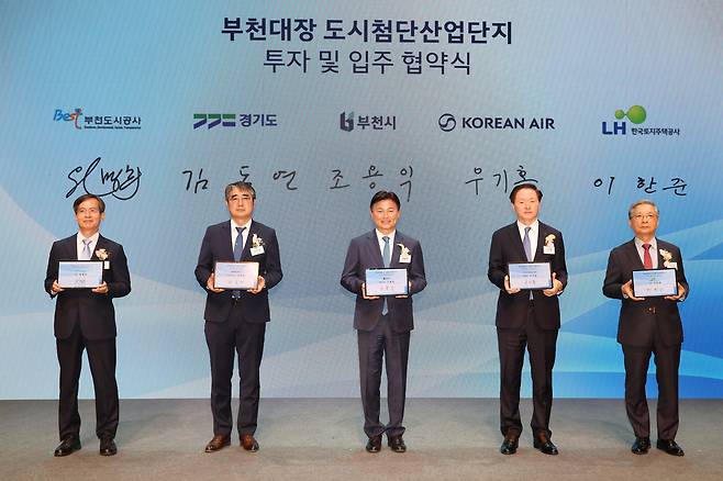 30일 부천아트센터에서 이한준 LH 사장(오른쪽 첫 번째), 우기홍 ㈜대한항공 부회장(오른쪽 두 번째), 조용익 부천시장(가운데), 손임성 경기도 도시주택실장(왼쪽 두 번째), 원명희 부천도시공사 사장(왼쪽 첫 번째)이 대한항공의 ‘UAM&Aviation Safety R&D센터(가칭)’ 입주를 위한 협약 체결 기념사진을 촬영하고 있다. /LH 제공