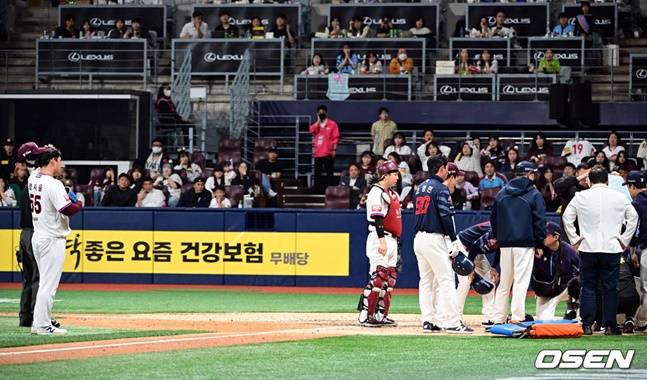 부상으로 쓰러진 전민재를 들것에 옮기려는 롯데 스태프들과 투수 양지율(왼쪽)이 어쩔줄 몰라하고 있다.