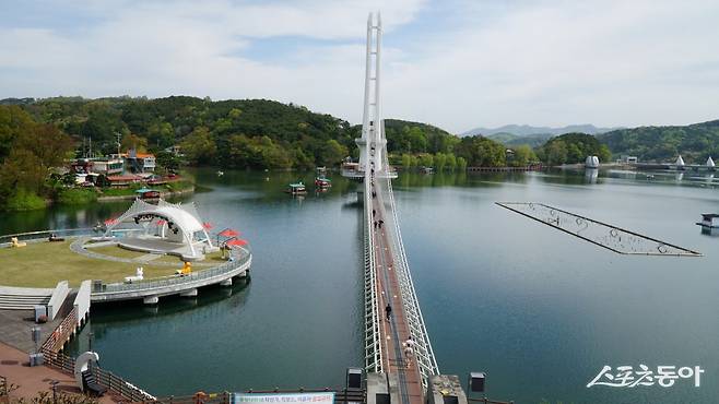 예당호 출렁다리와 예당호 전경. 왼쪽에 각종 공연을 할 수 있는 무대가 있고 오른쪽에는 이곳의 또 다른 명물거리 음악분수가 있다 충남|김재범 기자 oldfield@donga.com