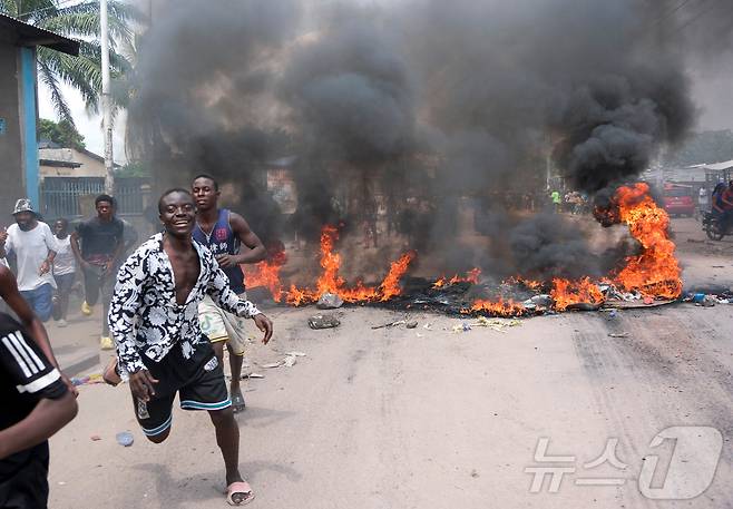 28일(현지시간) 콩고민주공화국 킨샤사에서 일어난 시위 도중 타이어 등이 불에 타고 있다. ⓒ 로이터=뉴스1 ⓒ News1 류정민 특파원