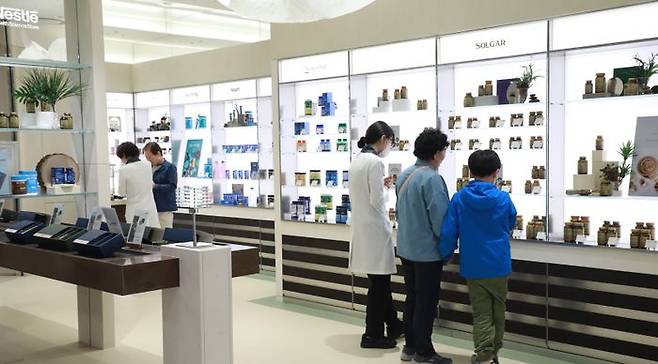 고객이 현대백화점 목동점 네슬레 헬스사이언스 매장에서 영양사와 함께 네슬레 헬스사이언스의 대표 건기식 브랜드 '솔가' 제품을 둘러보고 있는 모습ⓒ현대백화점