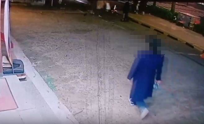 지난달 6일 서울 마포구에서 A 씨가 술병을 들고 외국인 관광객 뒤를 따라가는 모습