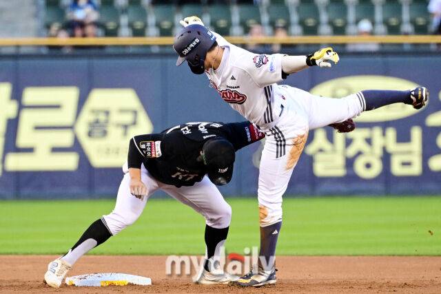 두산 박준영이 권동진의 태그를 피하기 위해 오른발을 높이 들고 있다.