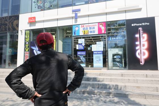 2일 서울 시내의 한 SK텔레콤 대리점 앞에서 한 소비자가 유심 재고 소진 안내문을 한참 바라보고 있다. 연합뉴스