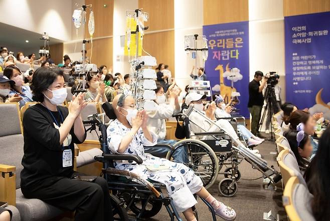 매직쇼 관람 중인 서울대어린이병원 환아와 그의 가족들.