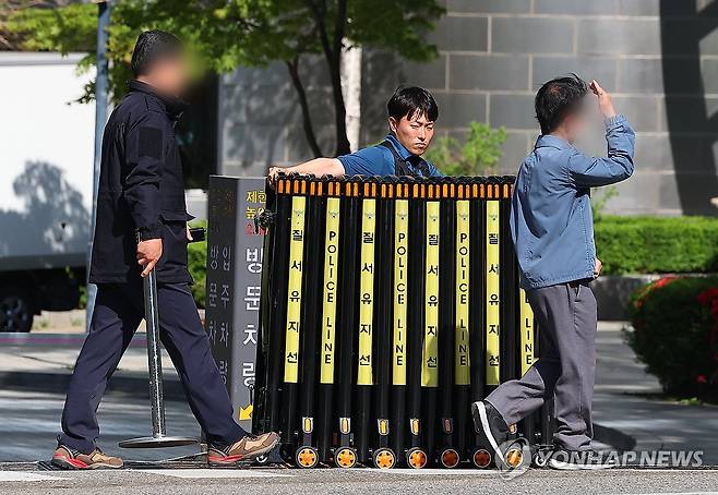 검찰, 건진법사 의혹 '윤 전 대통령 부부 사저' 아크로비스타 압수수색 종료 (서울=연합뉴스) 김도훈 기자 = 30일 서울 서초구 아크로비스타 앞에서 경찰 관계자가 검찰의 윤 전 대통령 사저에 대한 압수수색을 끝난 뒤 바리케이드를 치우고 있다. 2025.4.30 superdoo82@yna.co.kr