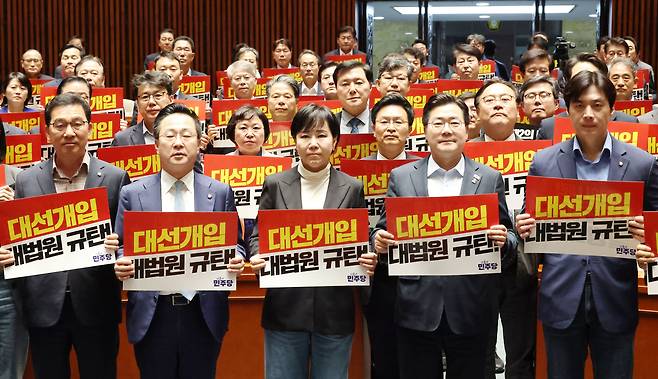 박찬대 더불어민주당 상임총괄선대위원장 등을 포함한 민주당 의원들이 4일 국회에서 열린 비상의원총회에서 ‘대선개입 대법원 규탄’이라고 적힌 손팻말을 들고있다. 한수빈 기자