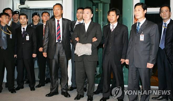 김경준 전 BBK 투자자문 대표 입국 (영종도=연합뉴스) 이정훈기자 = 김경준 전 BBK 투자자문 대표가 16일 인천공항을 통해 입국하고 있다. 김경준씨는 입국 게이트에서 취재진에게 30초 가량 사진촬영에만 응하고 계류장으로 빠져 중앙지검으로 떠났다.2007.11.16 uwg806@yna.co.kr