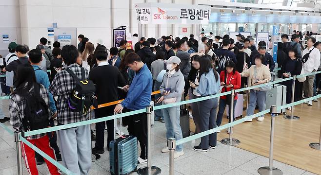 SK텔레콤 고객들이 연휴를 앞둔 2일 오전 서울 인천국제공항 제1여객터미널 출국장 SK텔레콤 로밍센터에서 유심 교체 서비스를 받기 위해 대기하고 있다./뉴시스