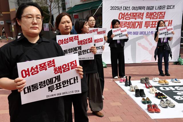 지난달 27일 서울 홍대입구역 인근에서 ‘젠더폭력 해결 페미니스트 연대’가 연 ‘2025 대선, 여성폭력 해결! 나중은 없다!’ 시위 참가자들이 손팻말을 들고 서 있다. 연합뉴스
