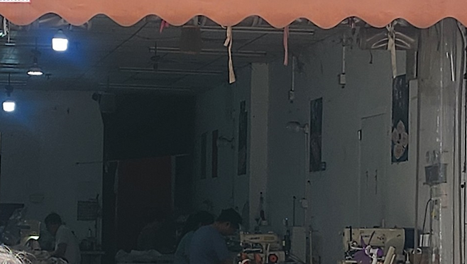 쉬인촌의 한 공장 모습. 한창 작업 중인데도 어떤 이유에서인지 한쪽에는 천장 선풍기는커녕 불도 켜놓지 않았다.