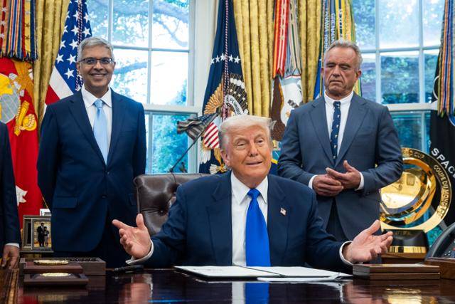 도널드 트럼프(가운데) 미국 대통령이 5일 미국 워싱턴DC 백악관 집무실에서 의료 관련 행정명령에 서명하고 있다. 워싱턴=EPA 연합뉴스