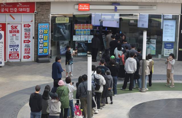 가입자 유심(USIM) 정보를 탈취당한 SK텔레콤이 유심 무료교체 서비스를 시작한 지 이틀째인 29일 서울 시내 한 SKT 대리점에 시민들이 줄을 서서 교체를 기다리고 있다. 연합뉴스