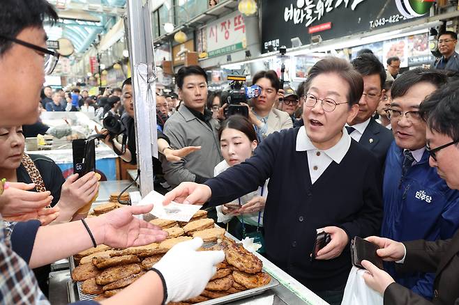 더불어민주당 이재명 대선 후보가 '골목골목 경청투어' : 단양8경편'에 나선 4일 충북 단양군 단양구경시장에서 떡갈비를 사먹으면서 지역화폐를 사용하고 있다./연합뉴스