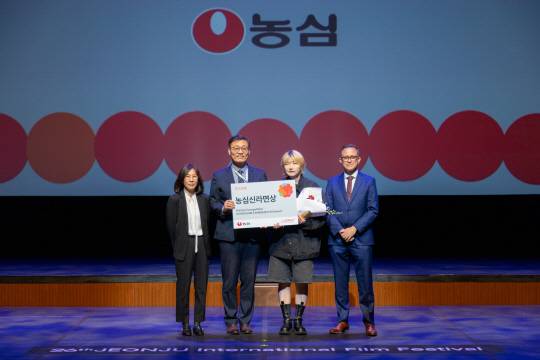 지난 6일 전주국제영화제에서 열린 '농심신라면상' 시상식에서 심규철(왼쪽 두번째부터) 농심 상무와 성스러운 감독이 기념촬영을 하고 있다. 농심 제공