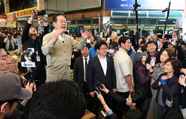 이재명 더불어민주당 대선 후보가 6일 ‘골목골목 경청투어’를 위해 충북 증평군 증평읍 장뜰시장을 방문한 자리에서 상인들의 애로사항 등을 듣고 지지를 호소하고 있다. 이 후보는 “정치인 조봉암 선생도 사법 살인됐고, 김대중 전 대통령도 사형 선고를 받은 일이 있다”고 말했다. 연합뉴스