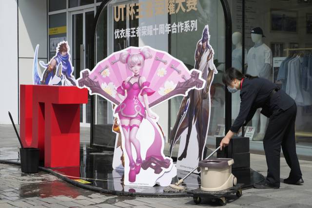 7일 한 직원이 베이징의 한 쇼핑몰 앞에 놓인 광고판 주변을 청소하고 있다. AP연합뉴스