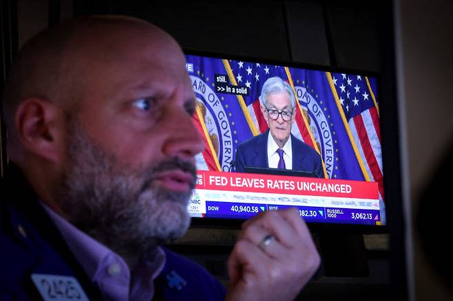 7일(현지시간) 미국 뉴욕의 뉴욕증권거래소(NYSE)에서 연준 금리 발표 후 제롬 파월 미국 연방준비제도 의장의 기자회견이 화면으로 중계되는 가운데 한 트레이더가 일하고 있다.(사진=로이터)