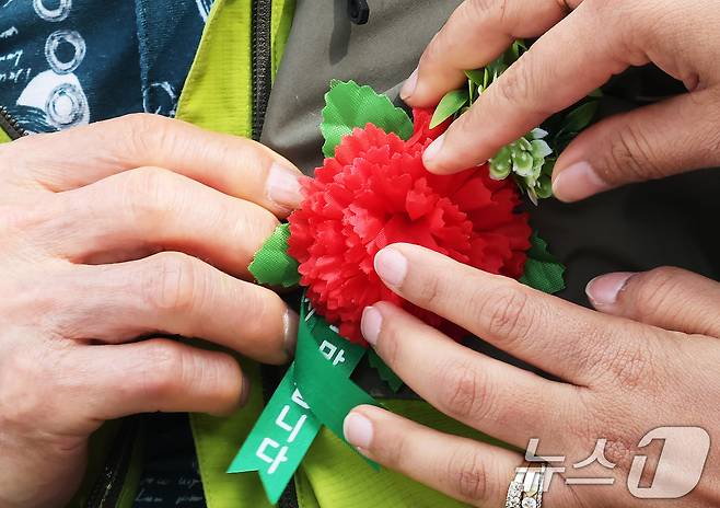 8일 오전 서울 동대문구 다일공동체 밥퍼나눔운동본부에서 열린 어버이날 행사를 찾은 어르신들이 봉사자들로부터 카네이션을 받고 있다. 2025.5.8/뉴스1 ⓒ News1 장수영 기자