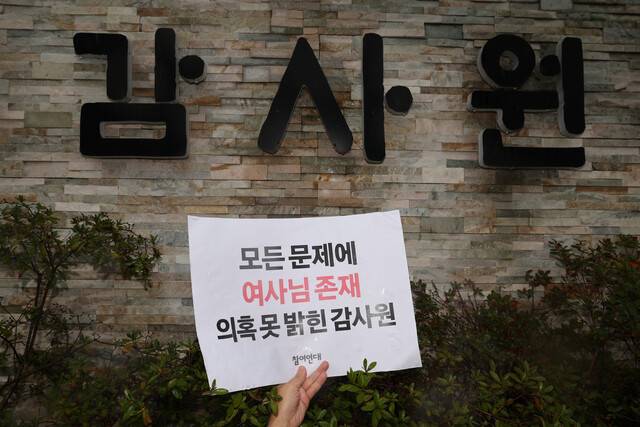 대통령실·대통령 관저 이전 불법 의혹 국민감사 결과가 나온 지난해 9월 12일 참여연대 관계자들이 서울 종로구 감사원 앞에서 감사 결과를 규탄하는 기자회견을 마친 뒤 감사원 정문 담벼락에 손팻말을 가까이 들고 사진을 찍고 있다. 김영원 기자 forever@hani.co.kr