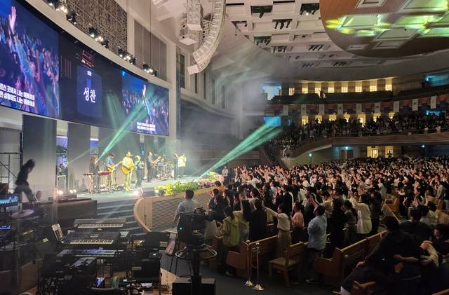 6일 서울 서초구 사랑의교회 본당에서 열린 크리스천 문화축제 ‘레디컬 페스티벌’에 참가한 1만2000여명의 청년이 성찬식을 하고 있다.