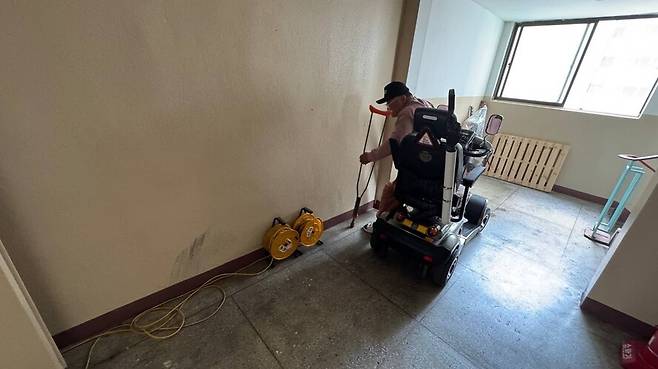 김철순씨가 지난 7일 서울 강서구의 한 아파트에서 복도에 전동스쿠터를 세운 뒤 충전하는 모습. 김수연 기자 link@hani.co.kr