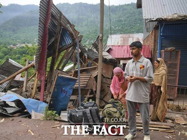 9일(현지시간) 인도령 카슈미르 우리 지역 긴갈 마을에서 한 가족이 밤사이 파키스탄의 포격을 받은 마을을 떠나며 대중교통을 기다리고 있다. /AP.뉴시스 /AP.뉴시스