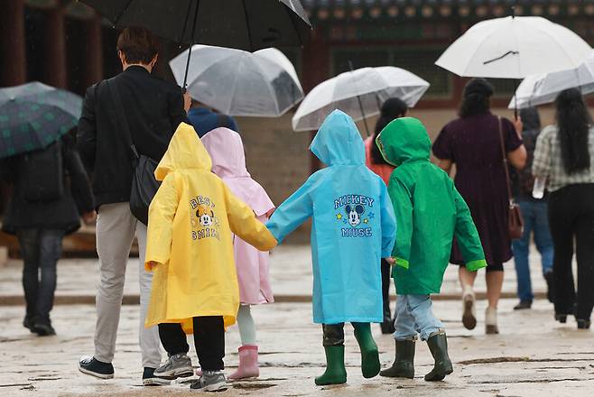 전국 대부분 지역에 비가 내린 9일 서울 종로구 경복궁에서 우비를 입은 어린이들이 손을 잡고 이동하고 있다. 연합뉴스