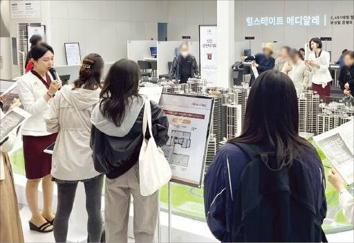 같은 날 개관한 은평구 ‘힐스테이트 메디알레’ 견본주택 내부 모형 앞에서 방문객이 도우미의 설명을 듣고 있다. /현대건설 제공
