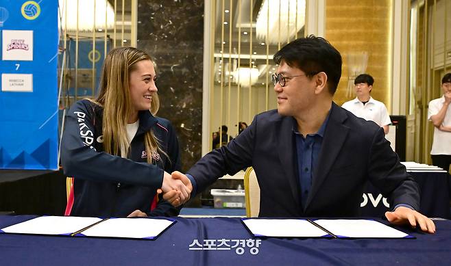 레베카 라셈(왼쪽)이 9일(현지시간) 튀르키예 이스탄불에서 열린 2025 한국배구연맹(KOVO) 여자부 외국인 선수 트라이아웃·드래프트 행사에서 마지막 7순위로 호명된 뒤 계약서에 사인하며 이영하 흥국생명 단장과 악수하고 있다. KOVO 제공