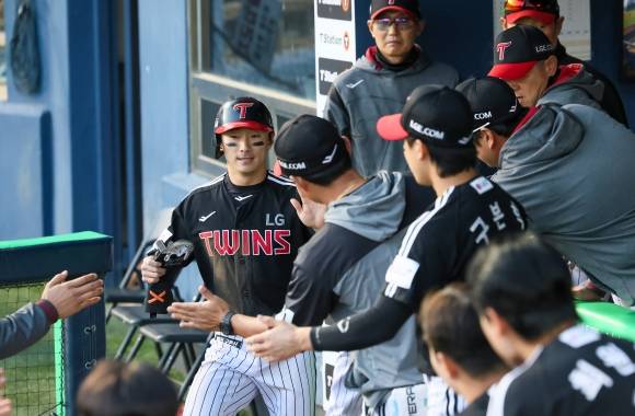 LG 트윈스 신민재가 7일일 서울 잠실야구장에서 열린 2025 KBO리그 정규시즌 두산 베어스의 원정 경기에서 득점한 뒤 동료들과 하이파이브하고 있다. LG 트윈스 제공