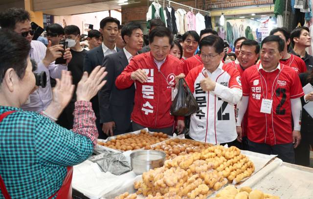 김문수 국민의힘 대선 후보가 13일 오후 울산 남구 신정시장을 찾아 도넛을 구매한 뒤 상인들과 인사하고 있다. 울산=성형주 기자
